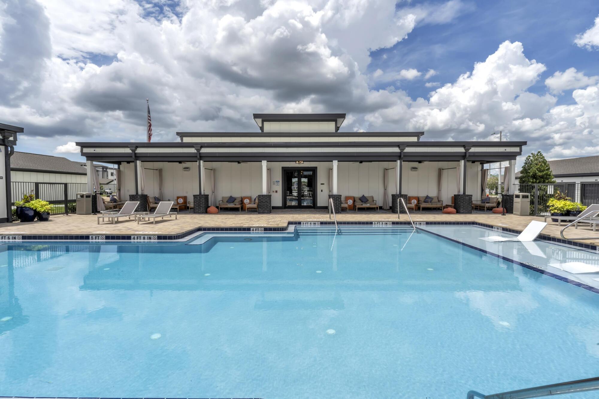 Sparkling blue swimming pool water and entry steps at the Pointe Grande Plant City amenity deck.