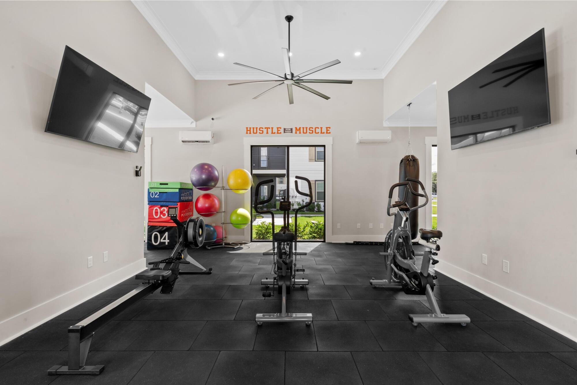 Dedicated yoga and spin studio at Pointe Grande Plant City with exercise balls, a spin bike, and wall mural.
