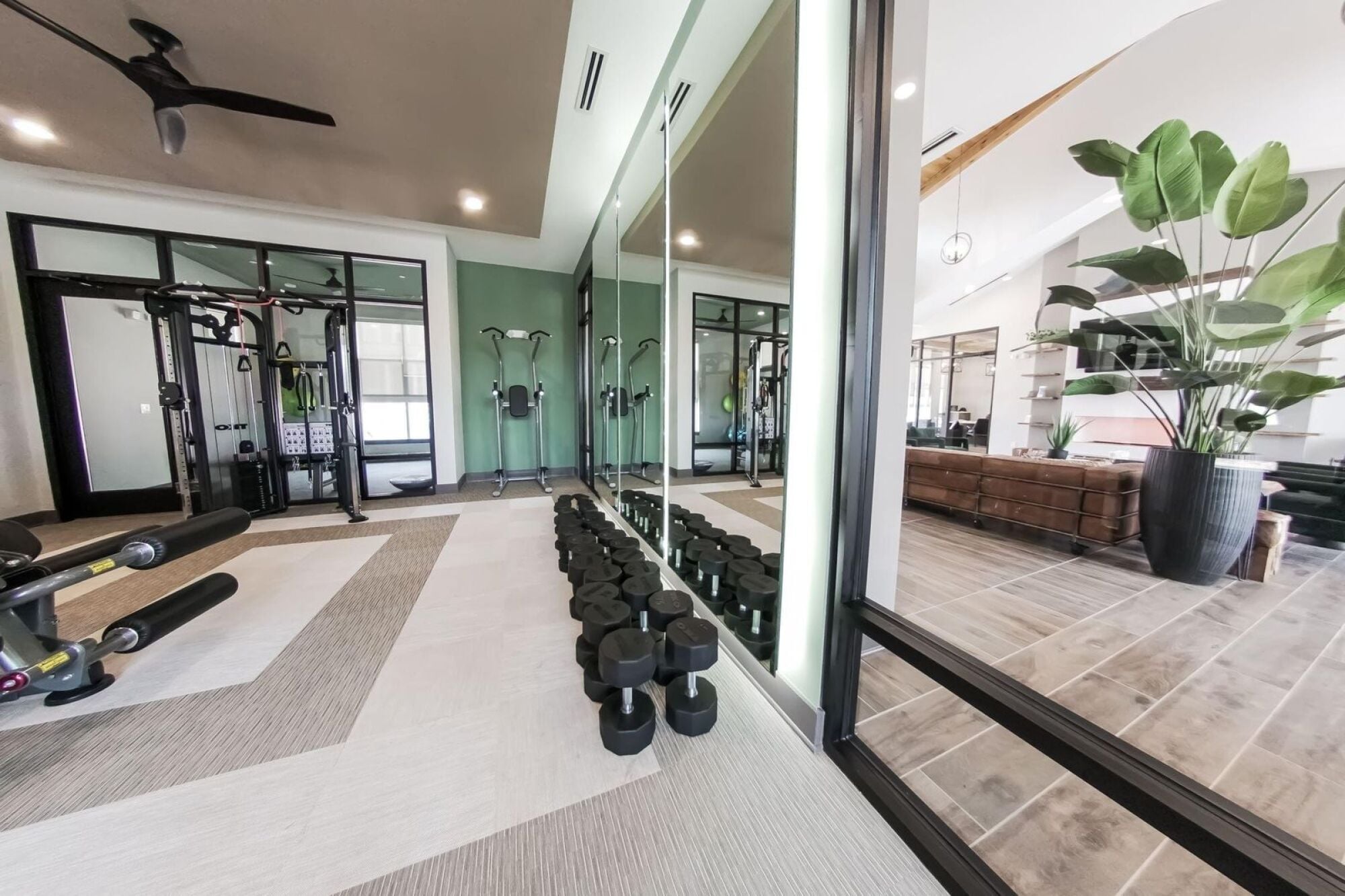 View of the well-equipped fitness center at Townhomes at Bridlestone with a range of exercise machines and a mirrored wall.