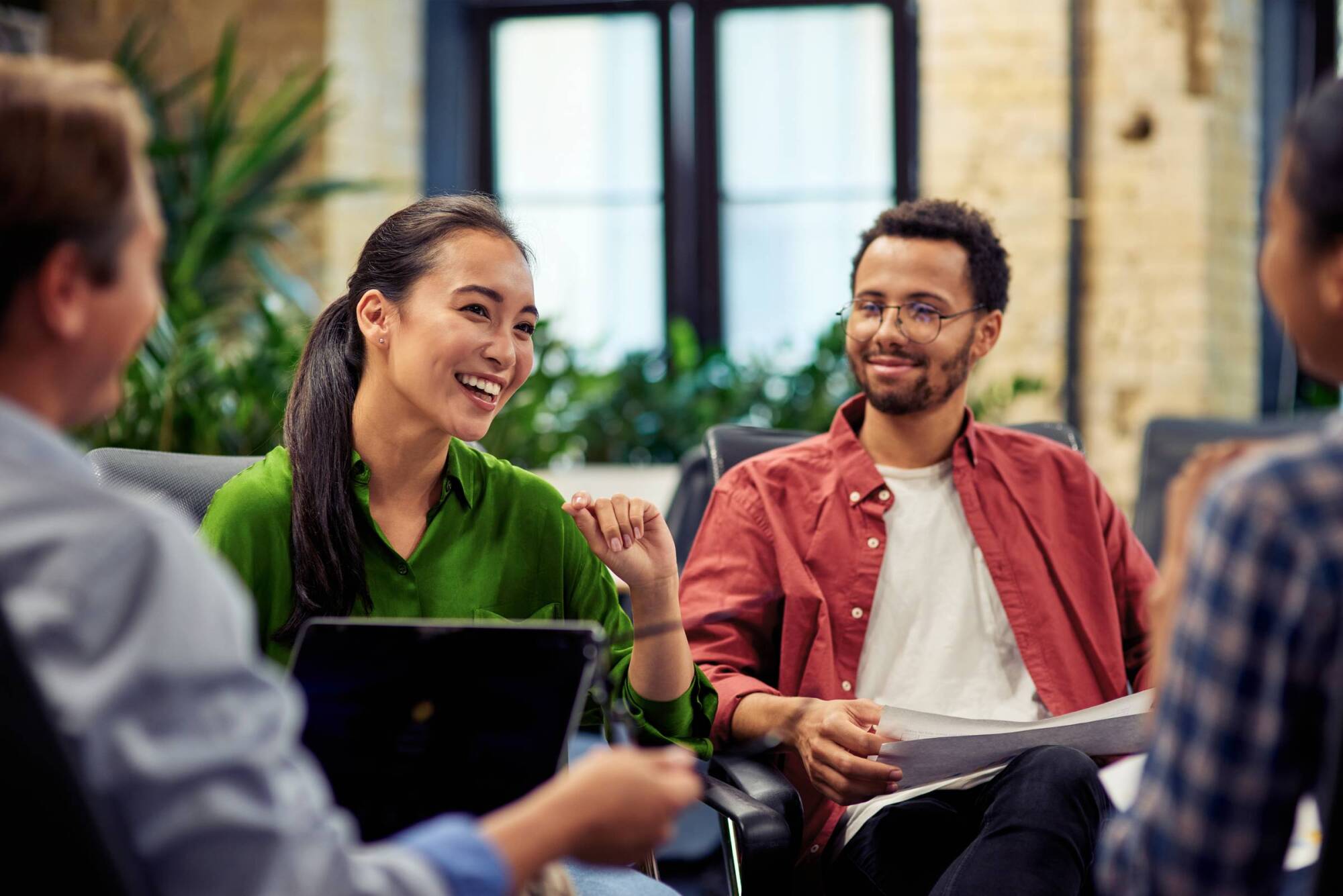 People gathered around in a professional setting, smiling at each other