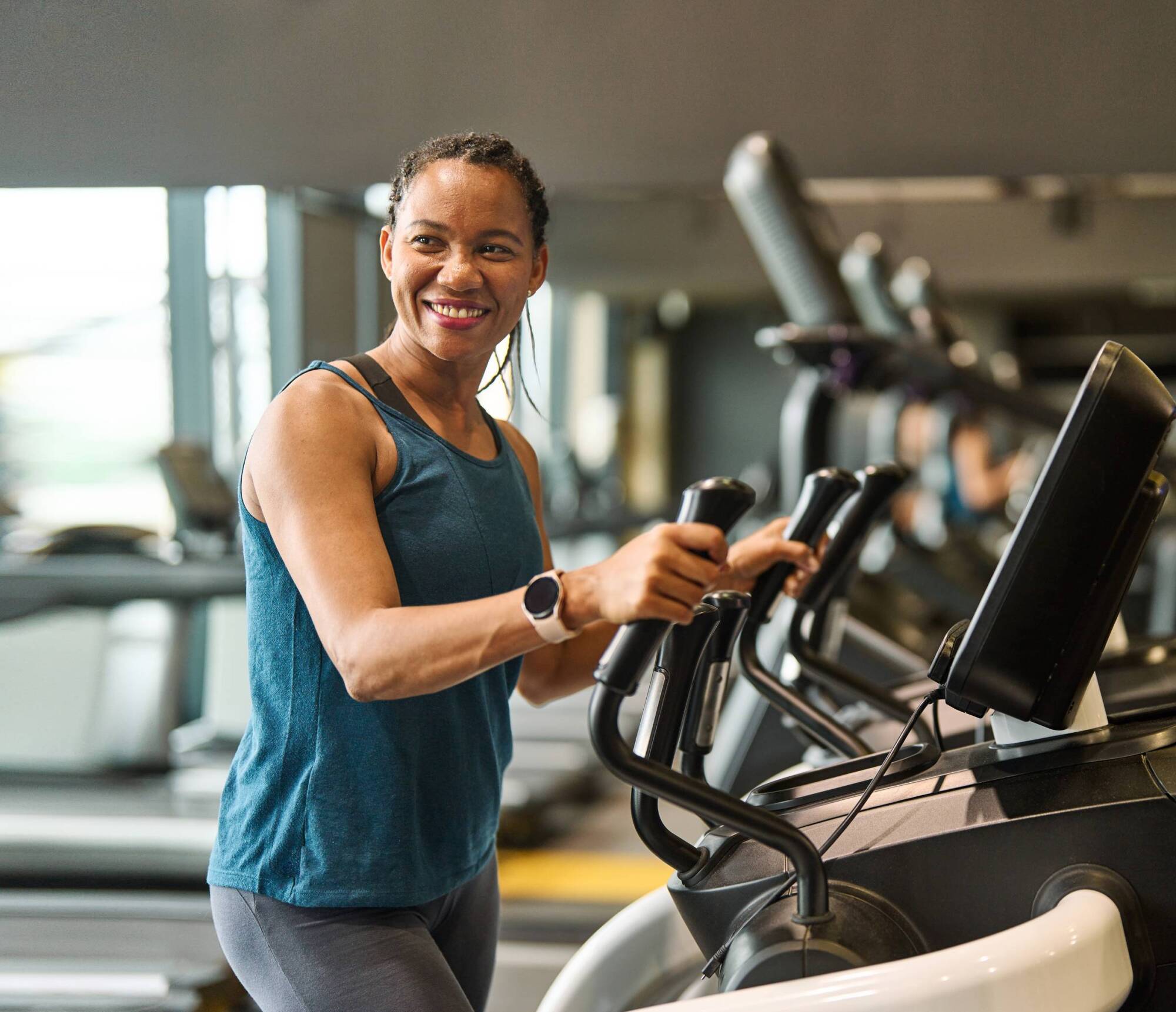Woman using workout equipment, smiling