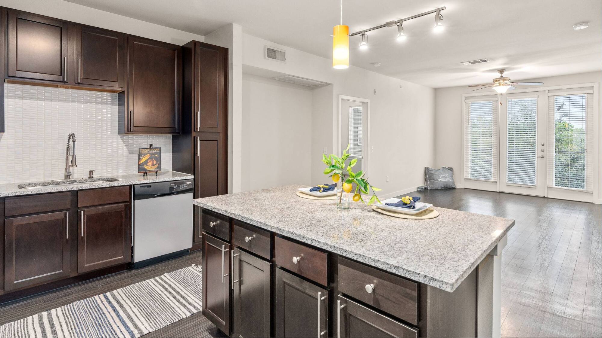 Modern kitchen with dark wood cabinets, stainless steel appliances, and granite countertops.