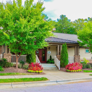 Townhomes at Chapel Watch Village on-site office building and entrance, surrounded by lush green trees and grass
