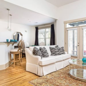 Townhomes at Chapel Watch Village living area with a couch, rug, coffee table and glass french doors out to a patio