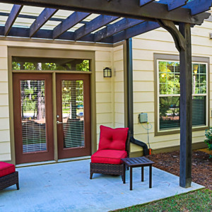 Townhomes at Chapel Watch Village townhome patio with french doors, two chairs, and grass