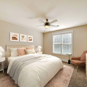 Townhomes at Chapel Watch Village townhome bedroom with a large bed, chair, rug, side table, lamp, ceiling fan, and window