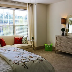 Townhomes at Chapel Watch Village townhome bedroom with a bed, love seat, dresser, and a large window