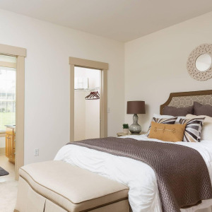 Townhomes at Chapel Watch Village townhome bedroom with a large bed, large closet, and an en suite bathroom