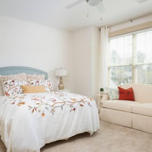 Townhomes at Chapel Watch Village townhome bedroom with a large bed, carpet, love seat, and a large window