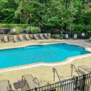 Townhomes at Chapel Watch Village community amenities with a saltwater pool, clubhouse, and surrounding grass and trees