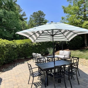 Townhomes at Chapel Watch Village community amenities with an outdoor patio table and umbrella lounge area