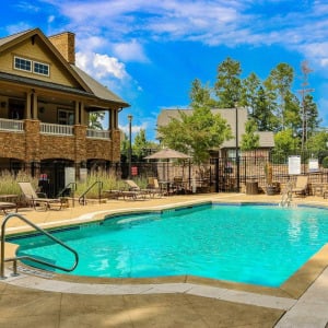 Townhomes at Chapel Watch Village community amenities with a saltwater pool, clubhouse, and surrounding grass and trees
