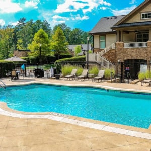 Townhomes at Chapel Watch Village community amenities with a saltwater pool, clubhouse, and surrounding grass and trees