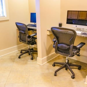 Townhomes at Chapel Watch Village community amenities with a business center with office chairs and computer stations
