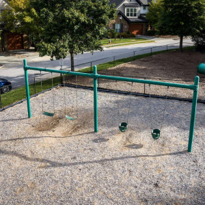 Townhomes at Chapel Watch Village community amenities with a fenced playground and swing set