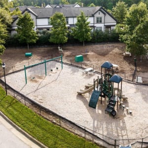 Townhomes at Chapel Watch Village community amenities with an aerial of the fenced playground and swing set