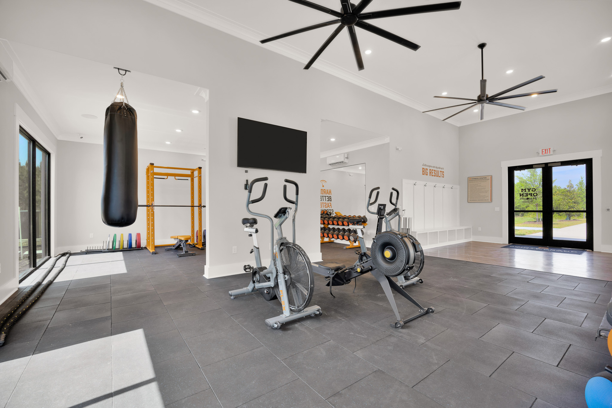 Spacious fitness center with cardio machines, weights, and a punching bag.