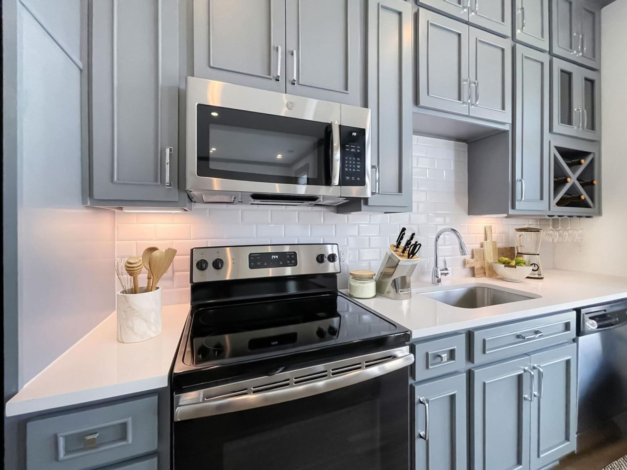 Jax kitchen featuring floor to ceiling cabinets and white tile backsplash