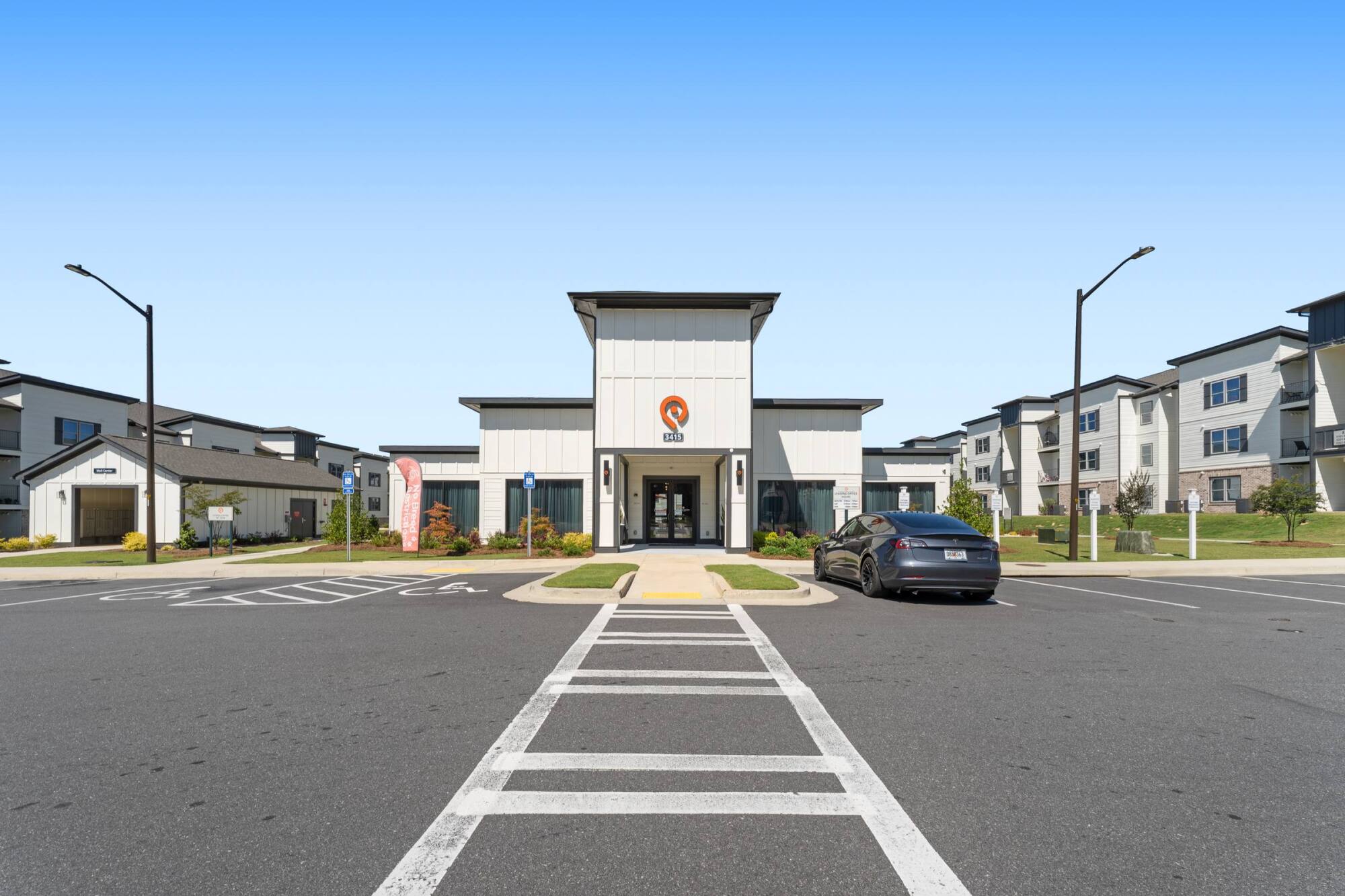 Main entrance to the apartment community with leasing office and parking