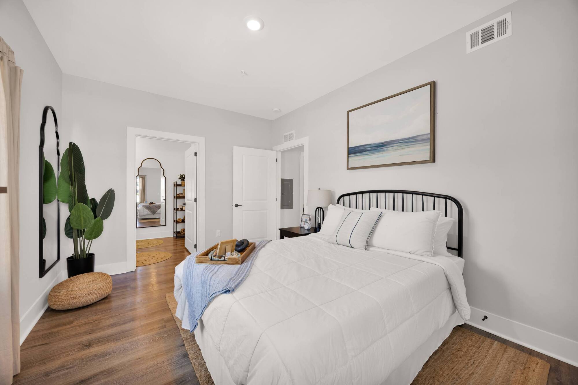 Bright bedroom with natural light, modern bed frame, and contemporary interior design in luxury residence