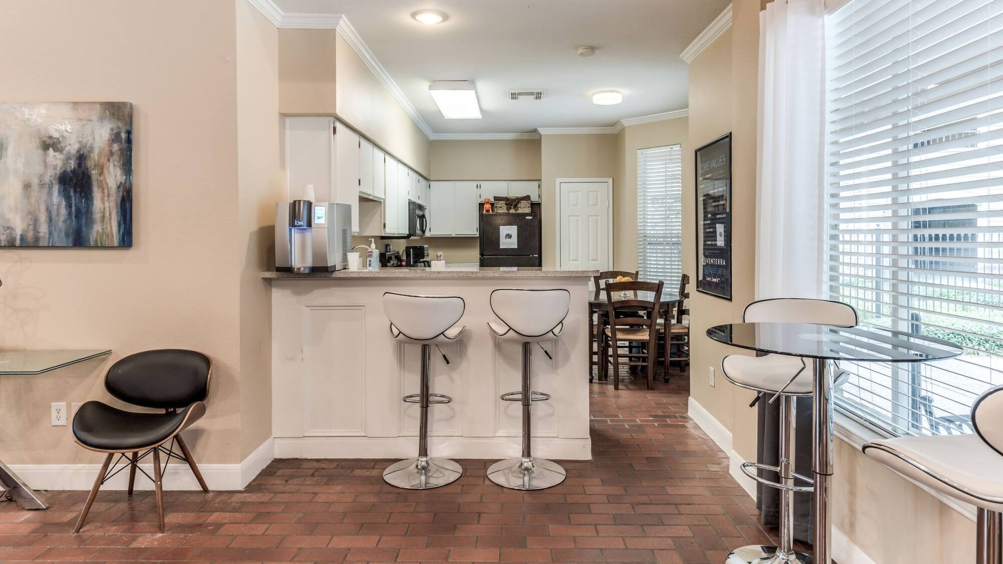 Complimentary coffee bar in the Forest View clubhouse in The Woodlands, TX, with barstool seating and a nearby dining table.