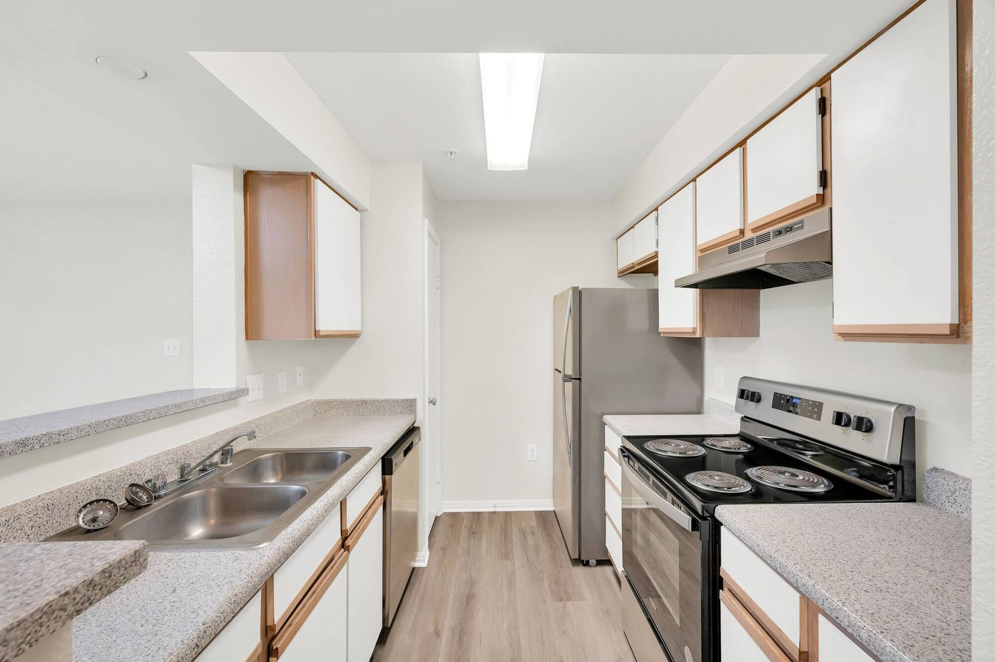 Galley kitchen in a Forest View apartment home with stainless steel appliances, a dishwasher, and generous counter space.