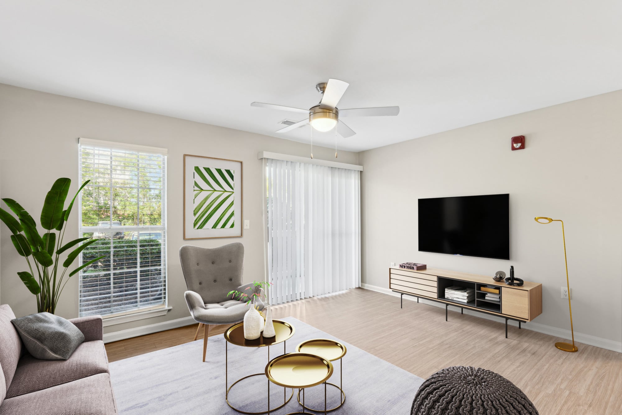Light-filled living area at Walker's Crossing with a ceiling fan and modern furniture.