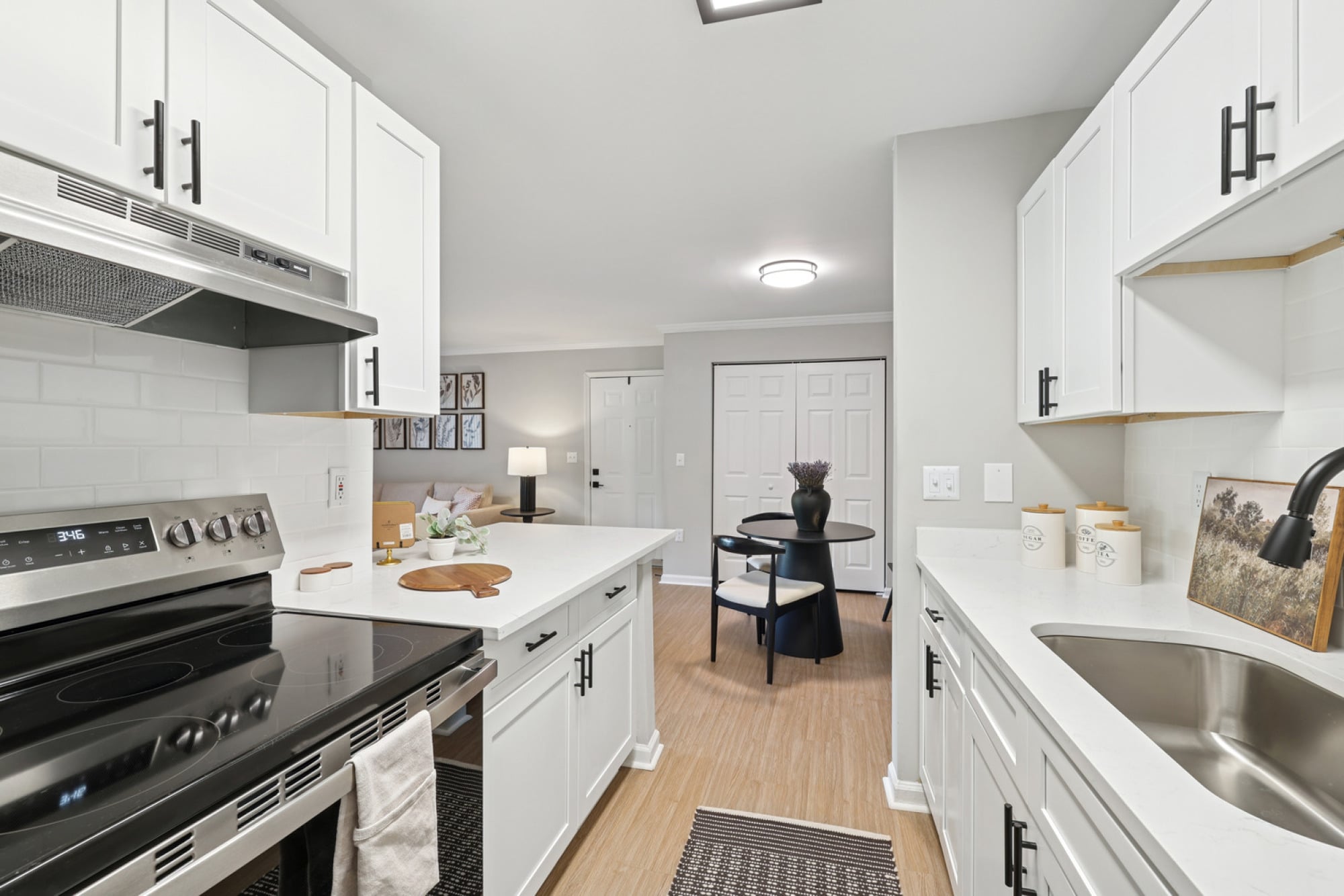 Bright kitchen at Walker's Crossing with white designer cabinetry and updated flooring.