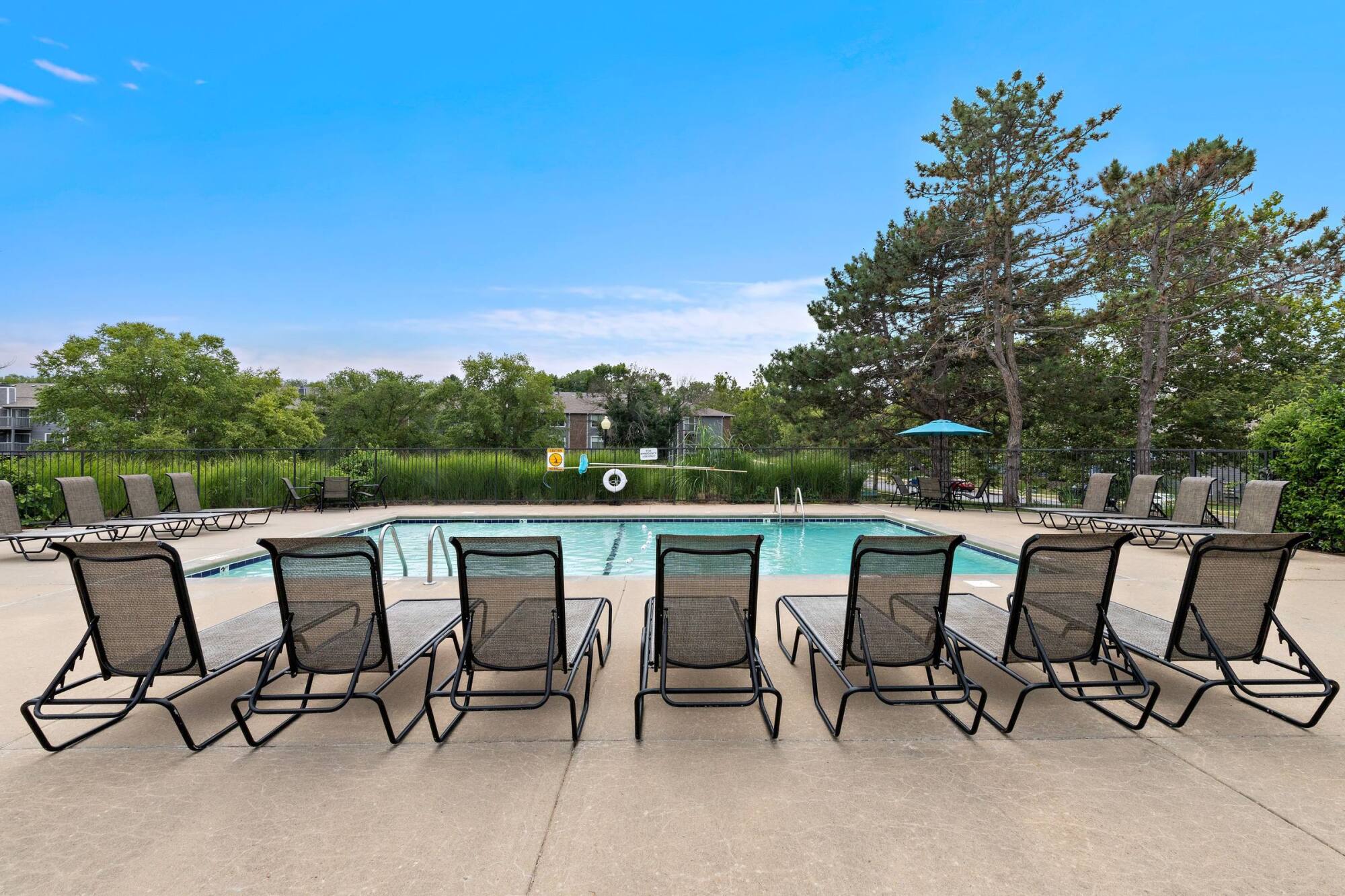 Lounge chairs lined along the sundeck at the Timberlane Village outdoor pool in Kansas City, MO.