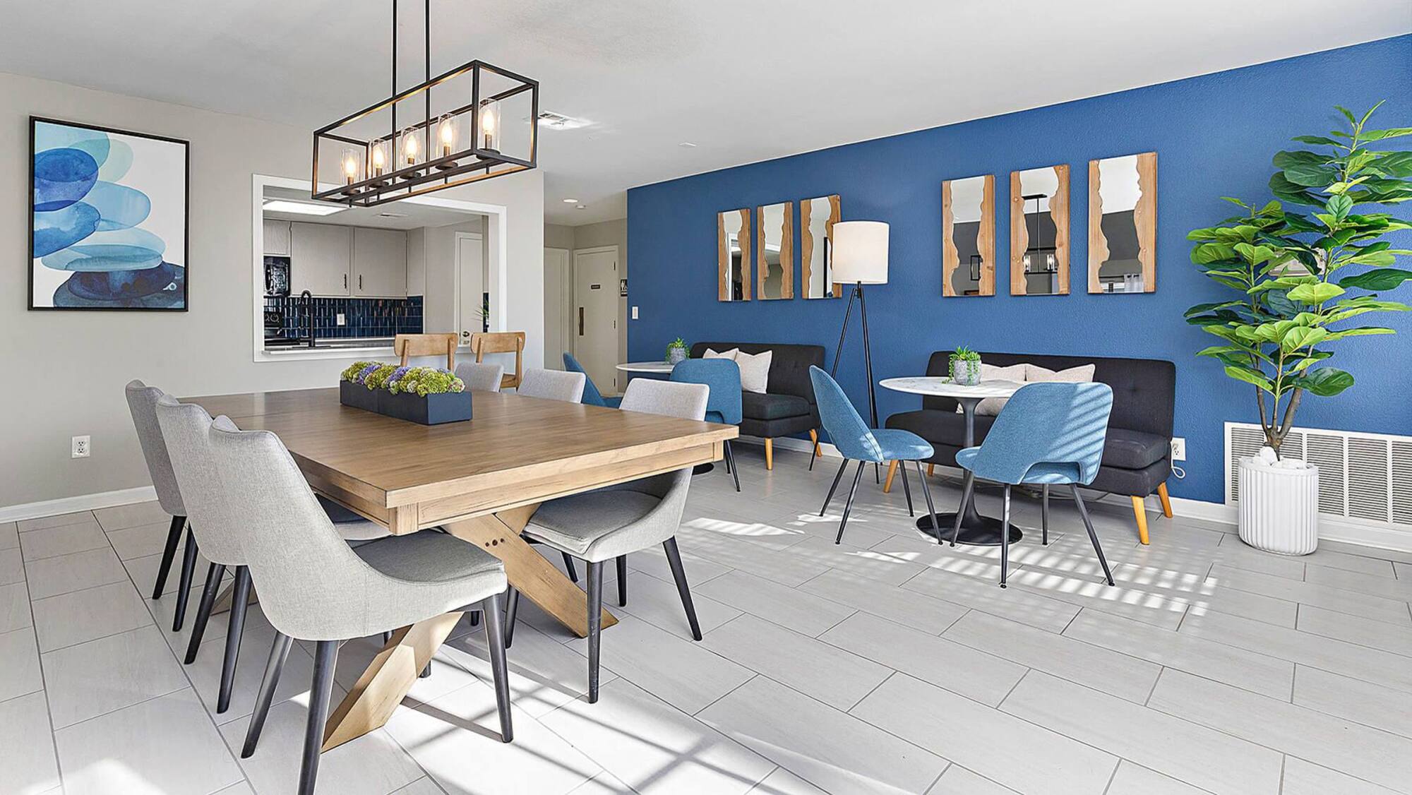 Community room at Timberlane Village Apartments with a farmhouse dining table, blue accent wall, and banquette seating.