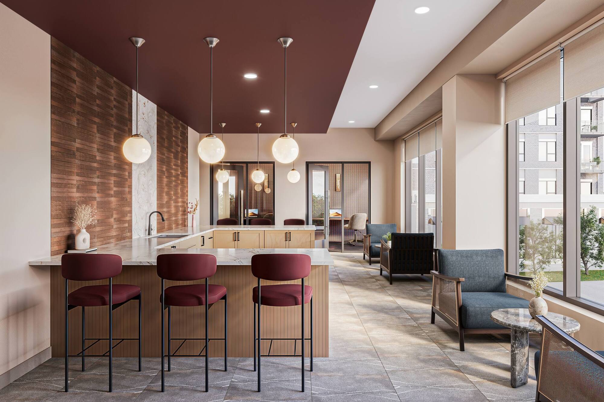 Modern kitchen lounge with maroon barstools, pendant lights, and large windows overlooking an apartment complex.