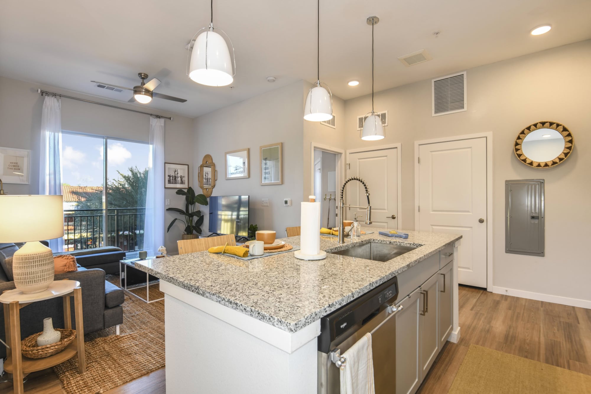 Open-concept apartment kitchen overlooking the living room with balcony views at Stadium House