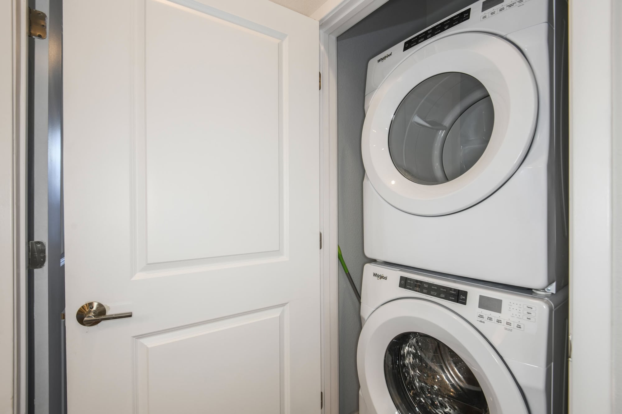In-unit stacked Whirlpool washer and dryer closet at Stadium House apartment
