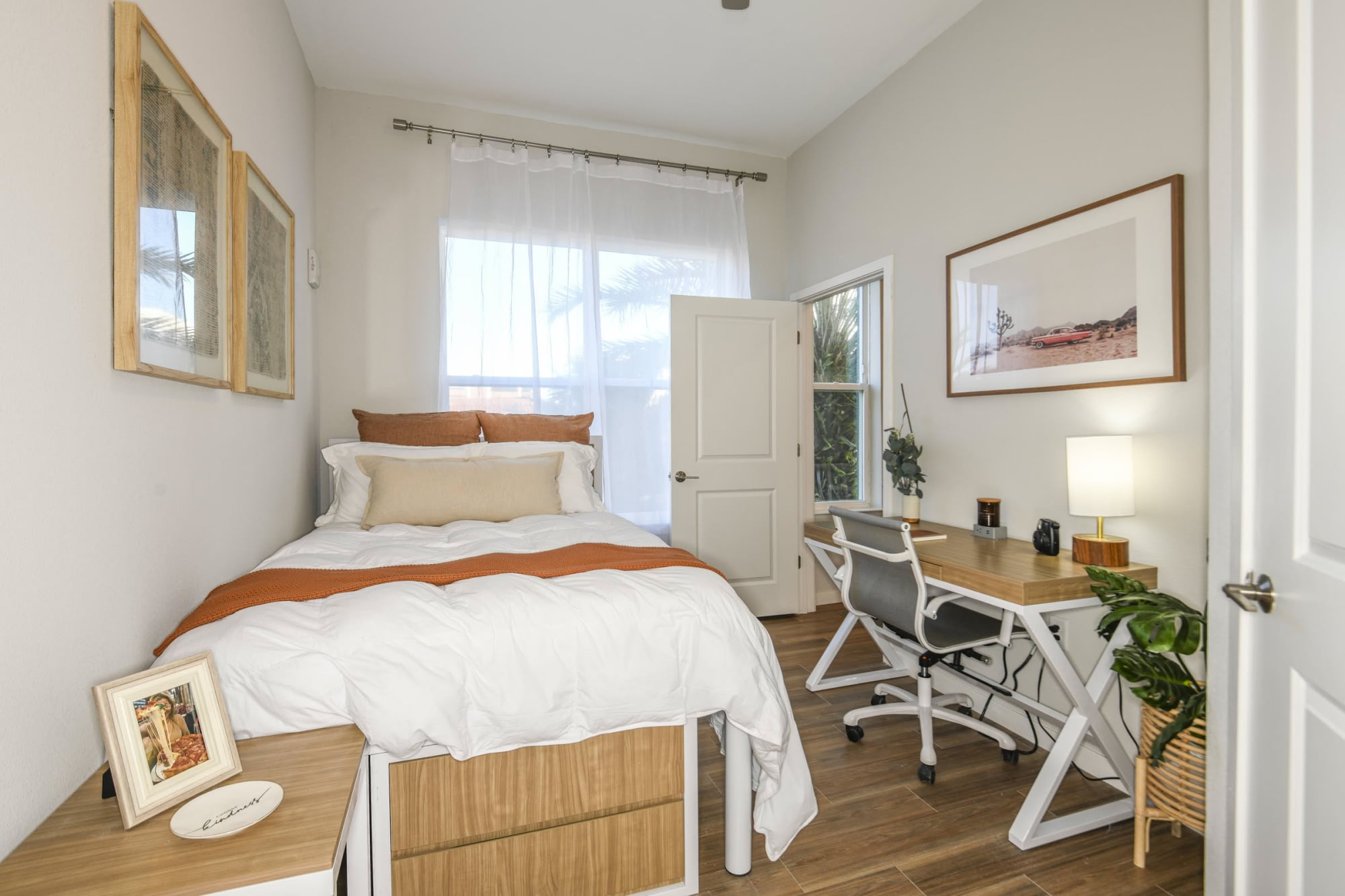 Apartment bedroom with queen bed, desk workspace, and natural light at Stadium House