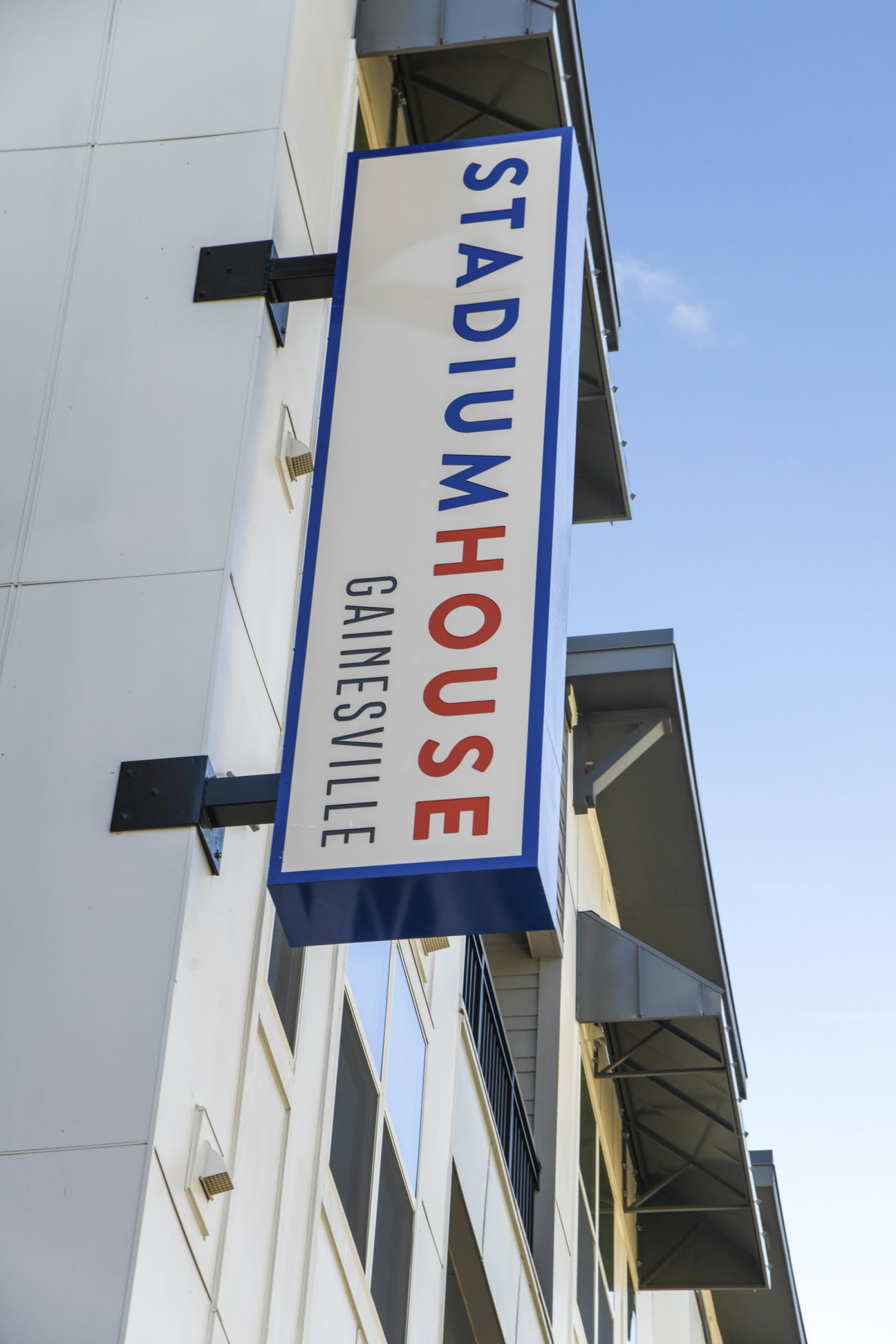 Stadium House Gainesville exterior signage on the white-paneled apartment facade