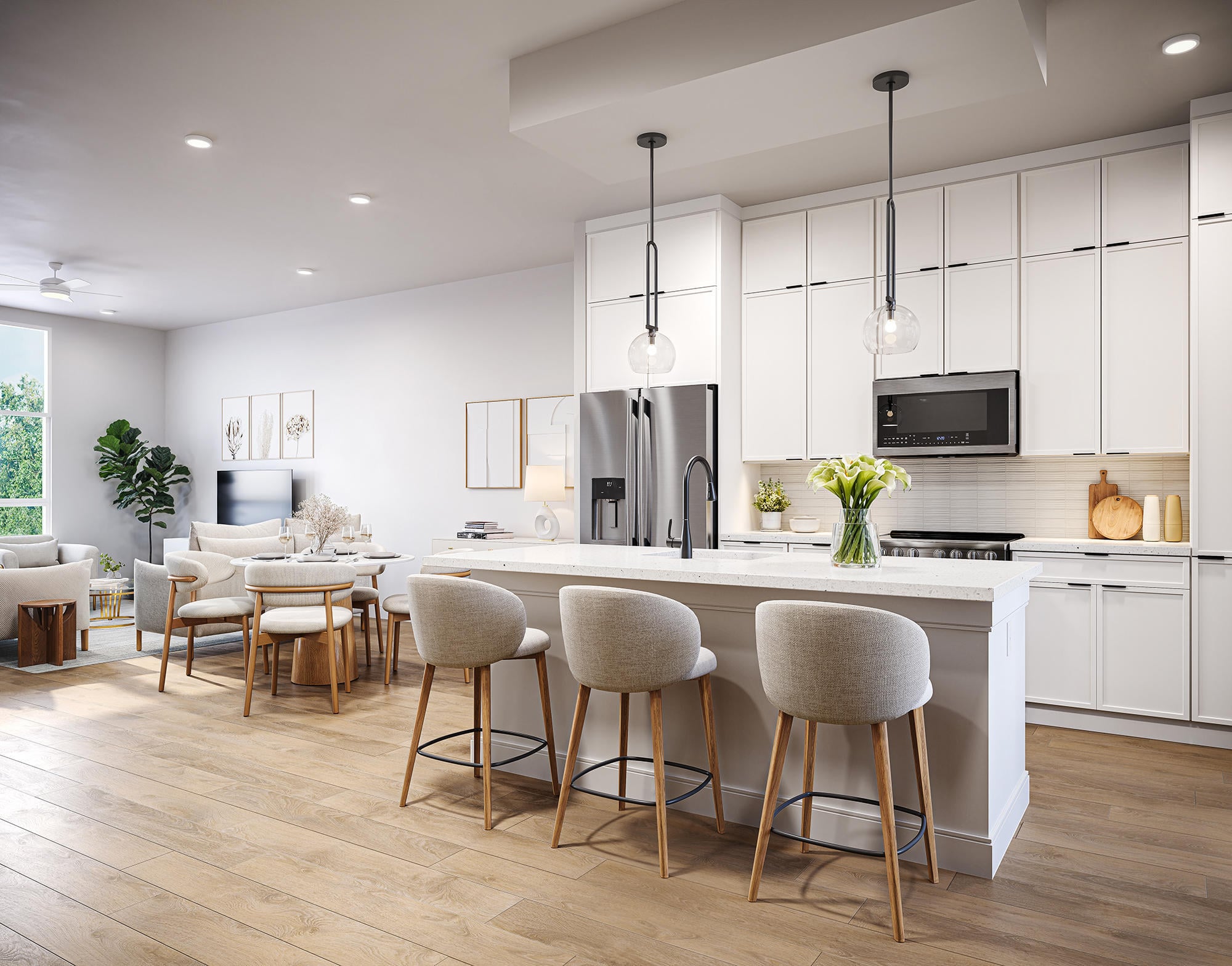 Modern white kitchen with island, barstools, pendant lights, and dining area; bright and spacious layout.