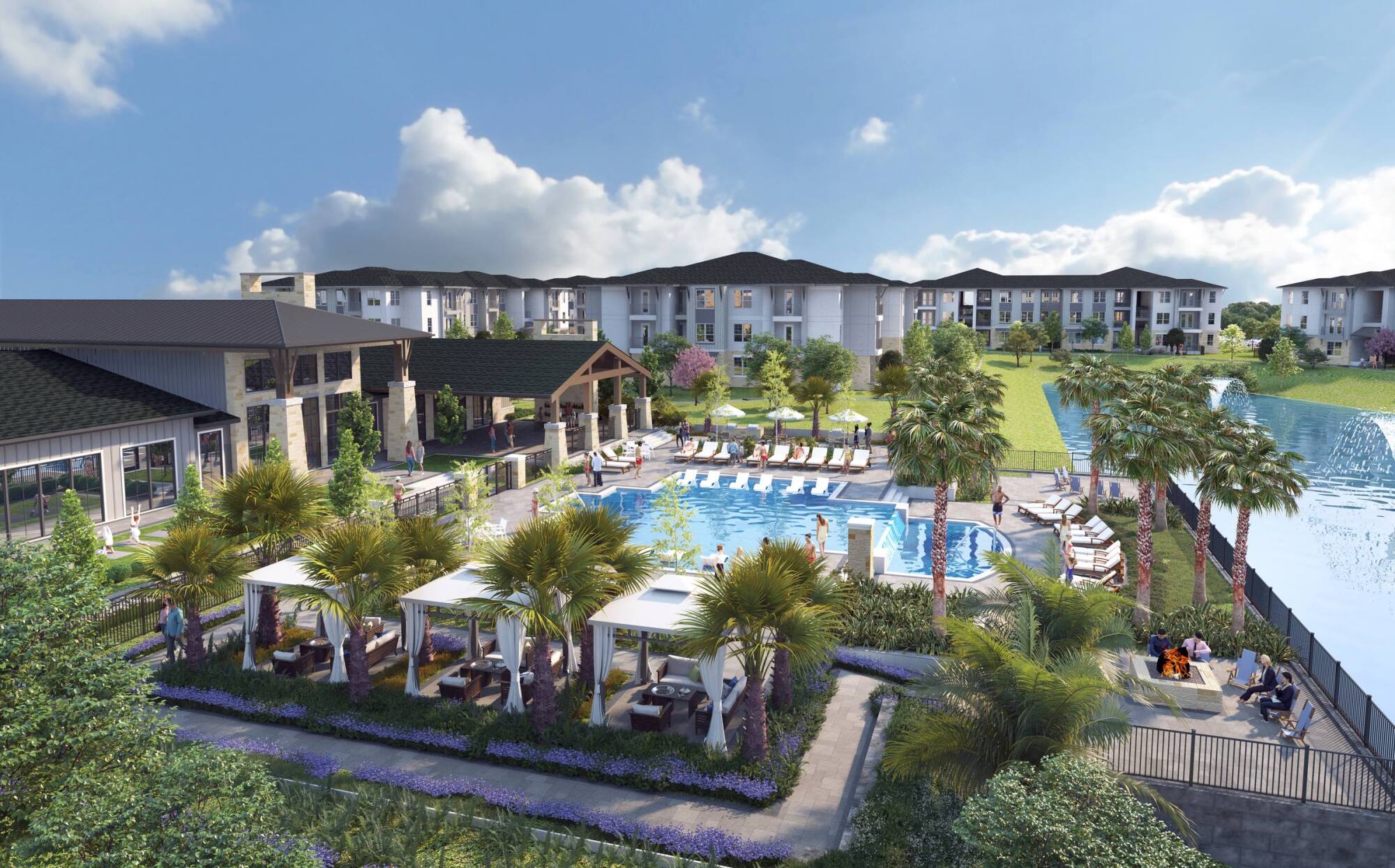 Aerial view of a luxury apartment complex with a pool, cabanas, palm trees, and a pond on a sunny day.