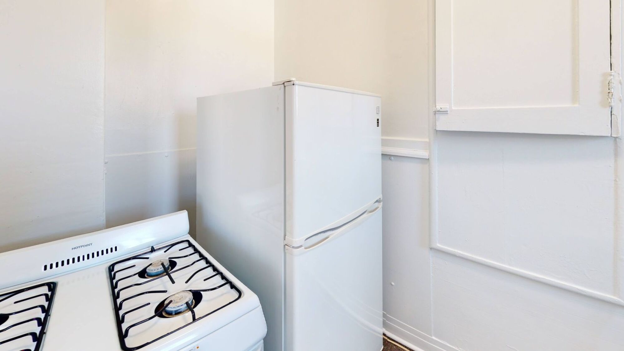 A white stove and refrigerator in a kitchen.