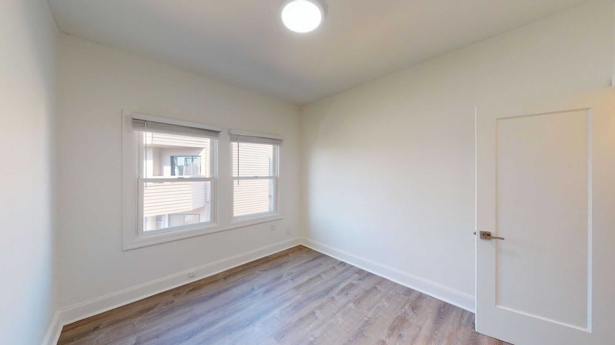 A room with a wooden floor and a white door.