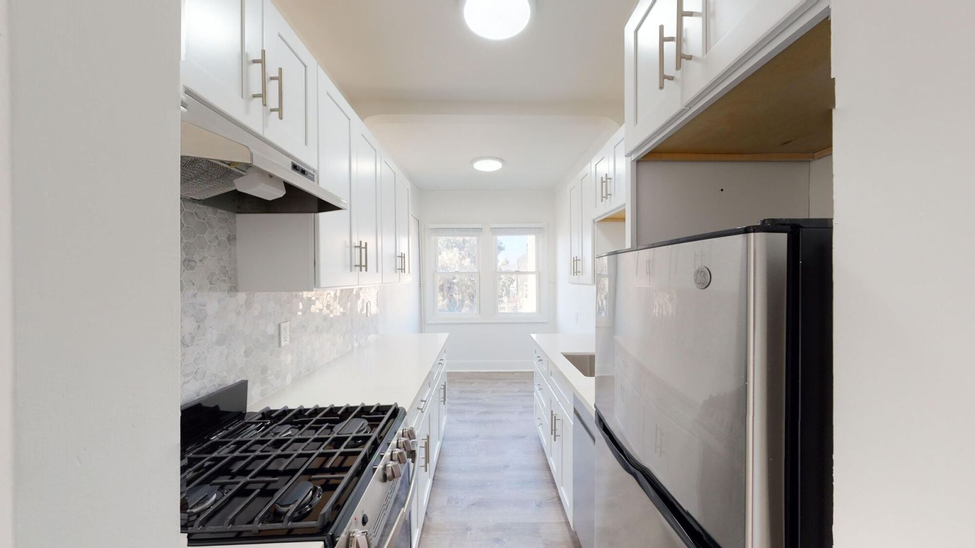 A modern kitchen with a stove and a refrigerator.