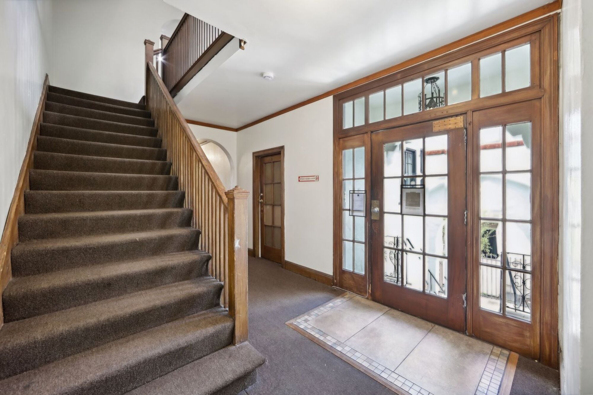 A staircase with a carpeted runner and wooden banister.