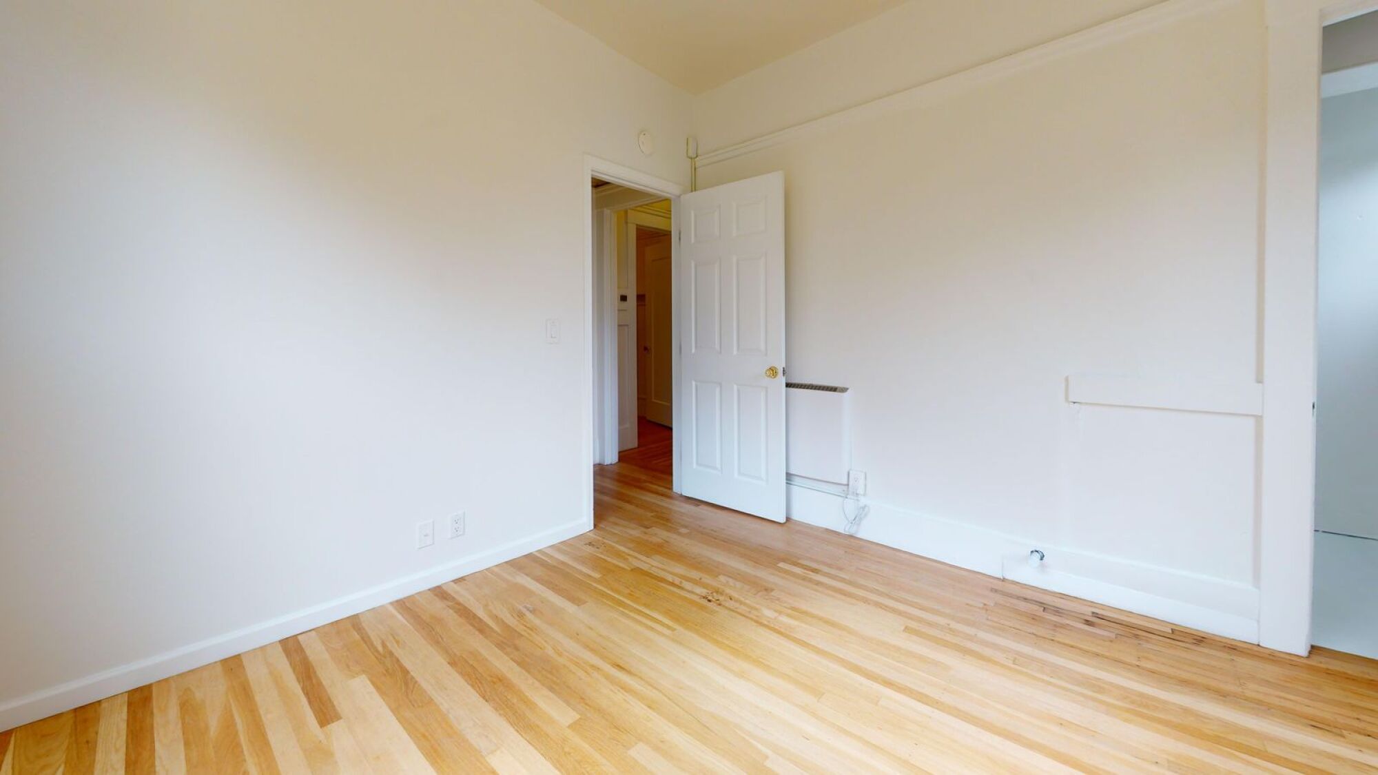 A room with wooden floors and white walls.
