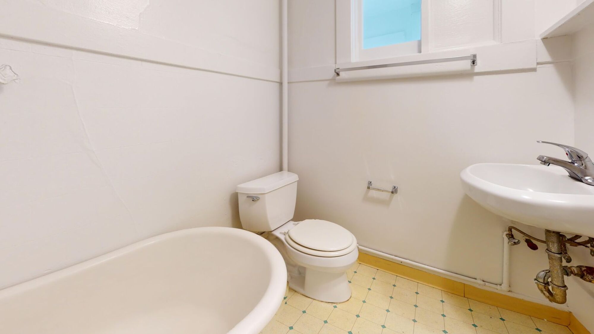 A white bathroom with a tub, toilet and sink.