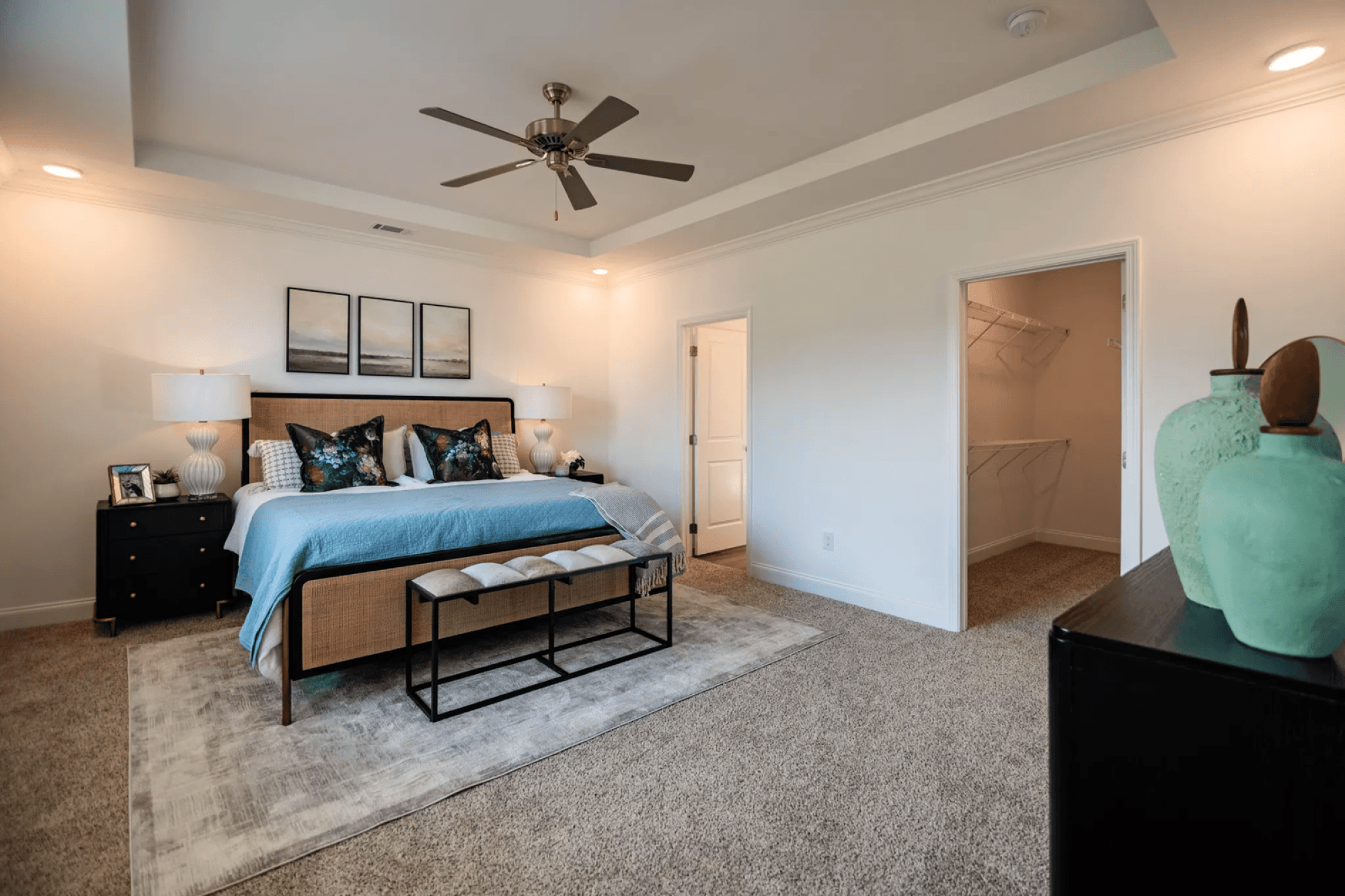 A bedroom with a bed, nightstands, and a ceiling fan.