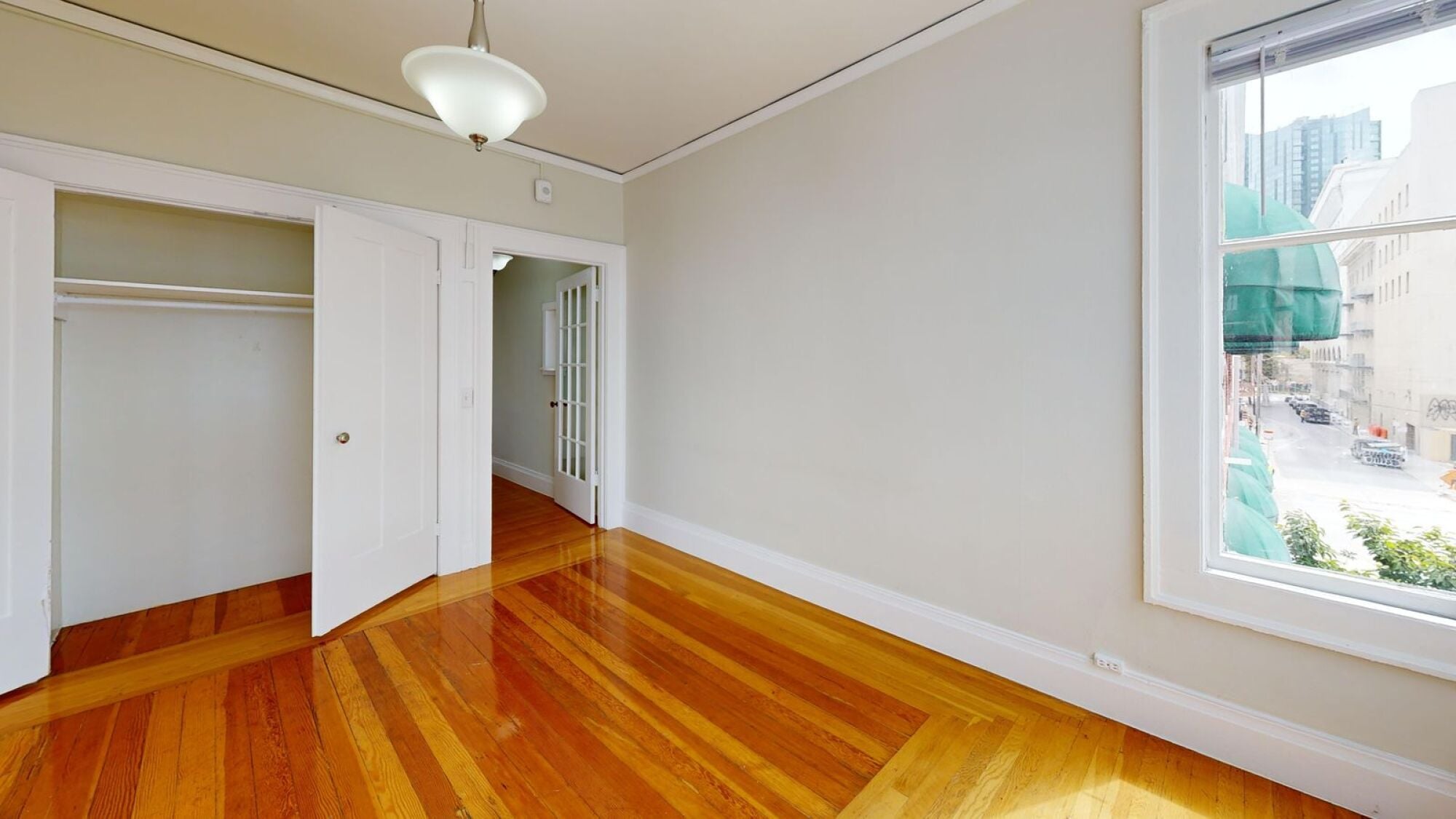 A room with wooden floors and a large window.