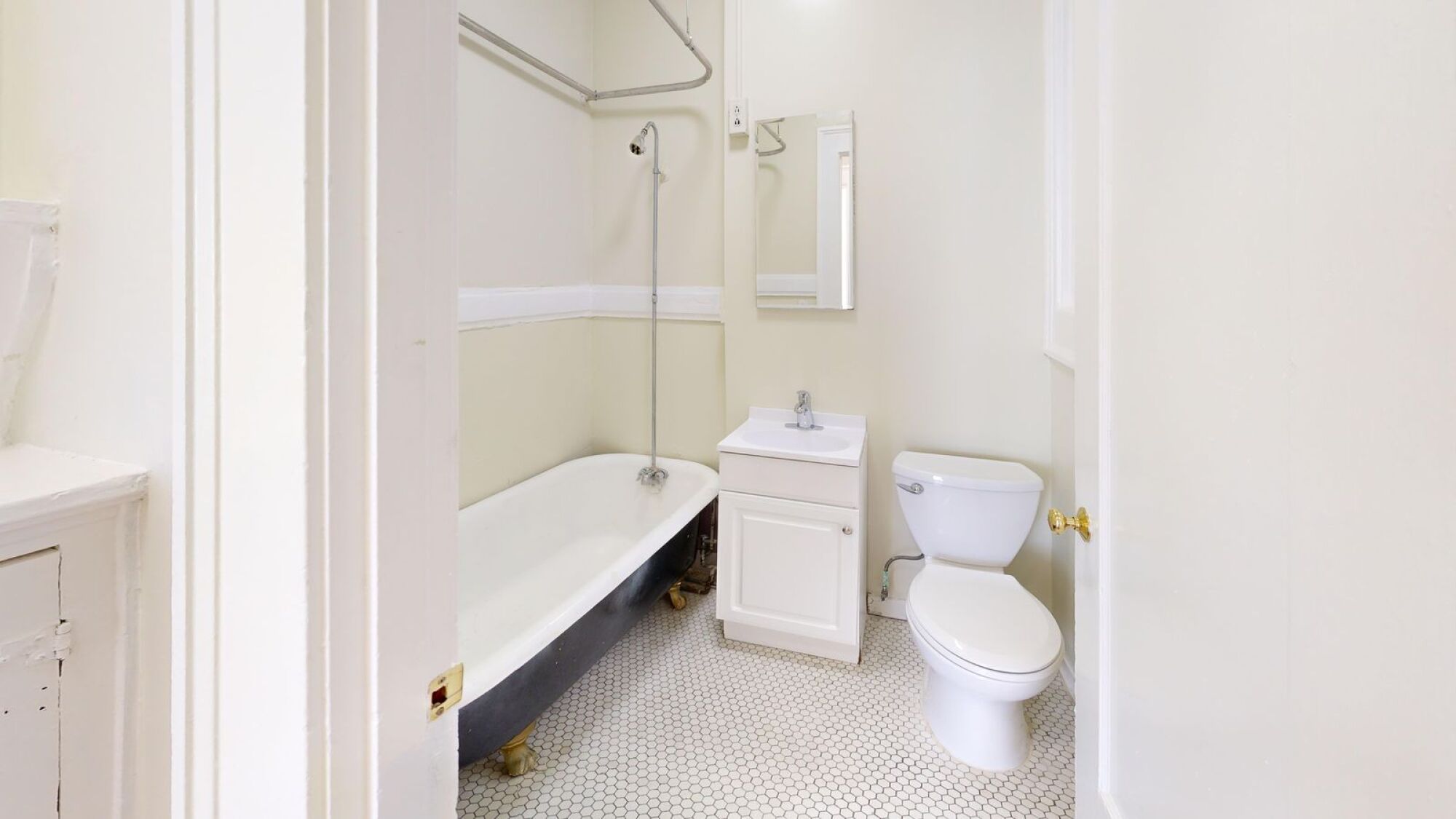 A white toilet sits next to a white sink in a small bathroom.