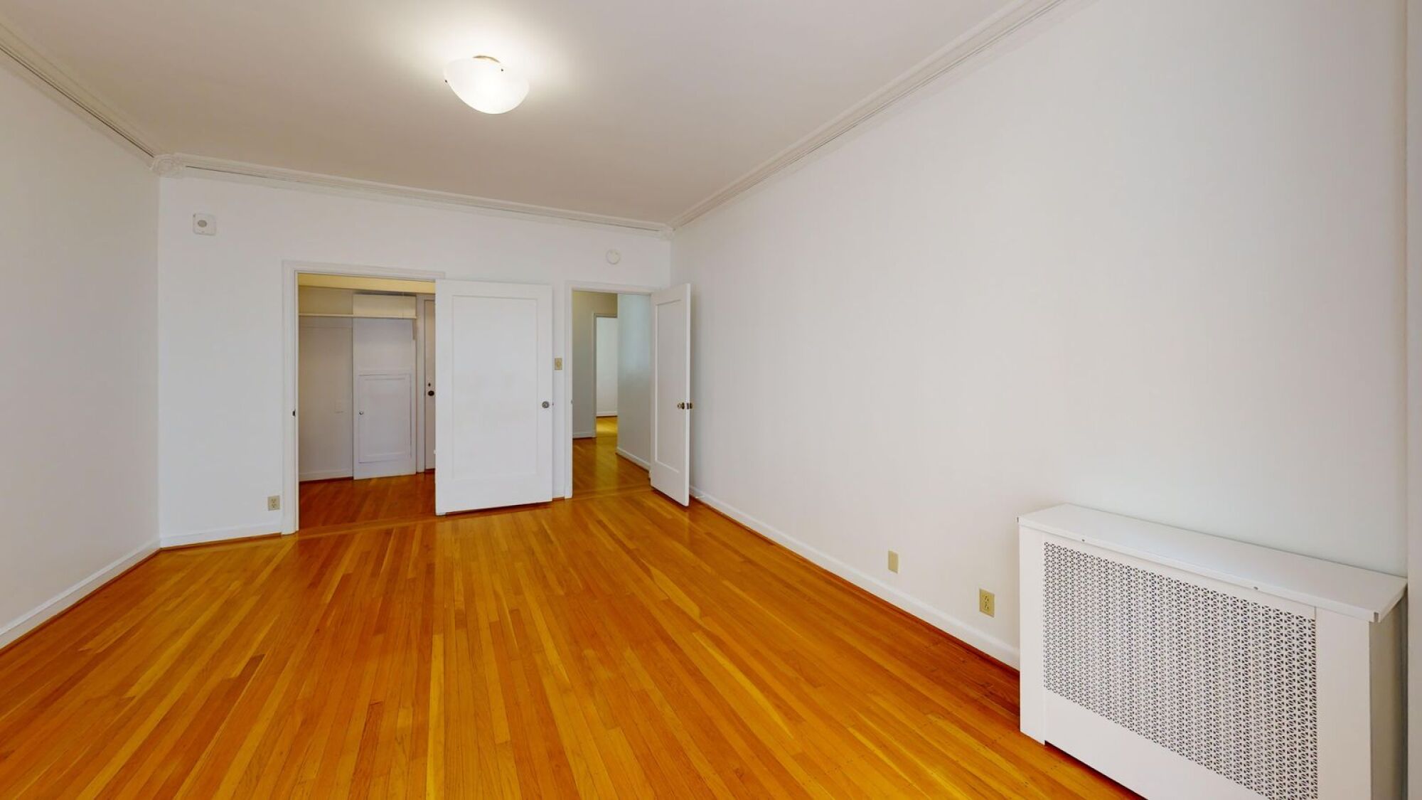 A room with a white wall and a wooden floor.