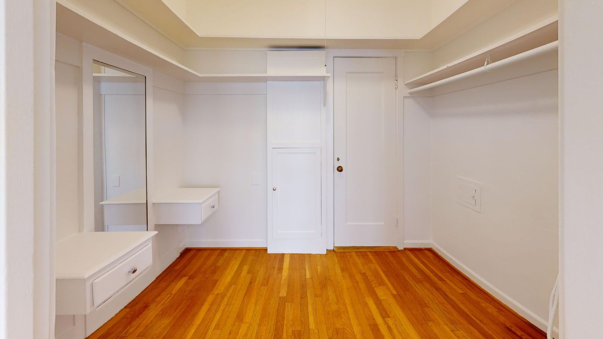 A room with a wooden floor and white walls.