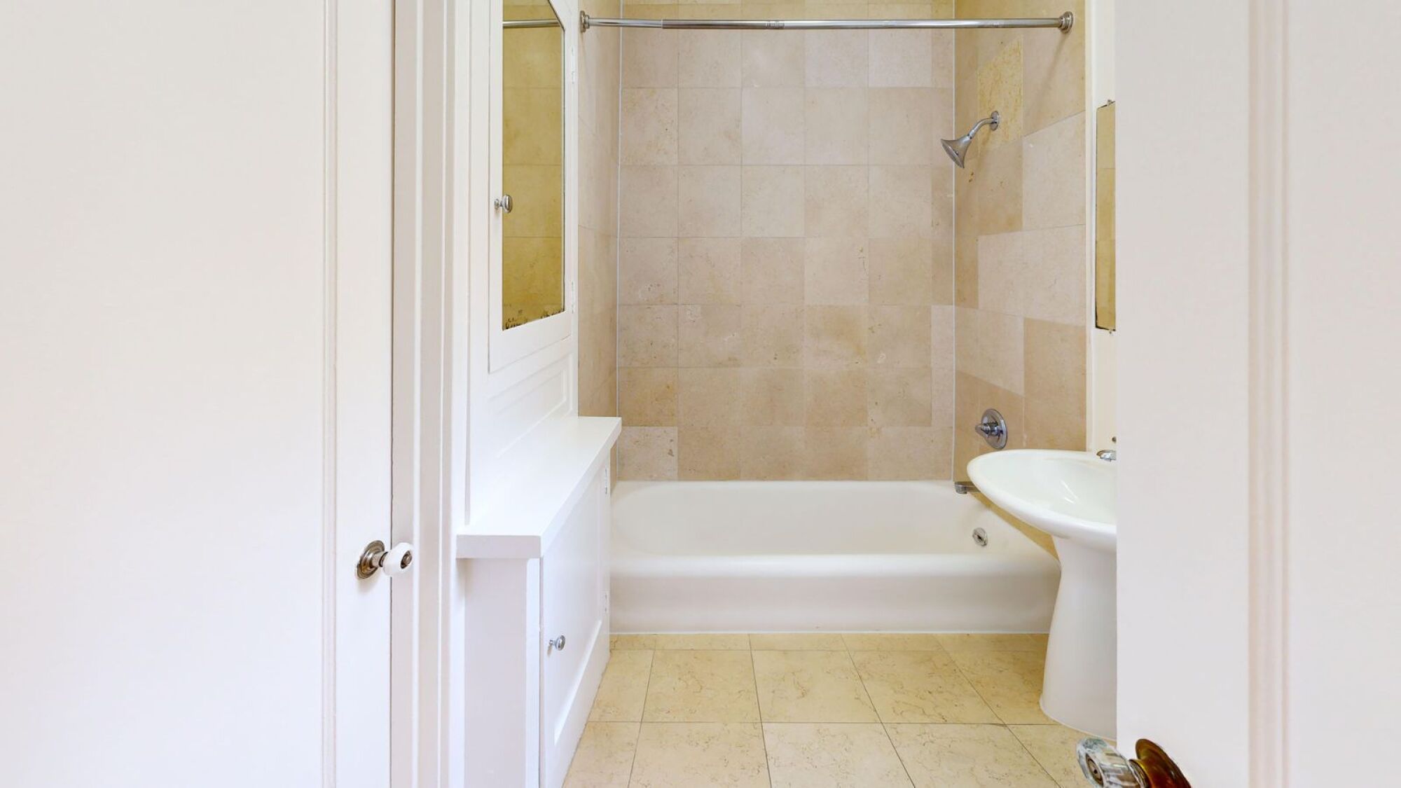 A white bathroom with a tub, sink and toilet.