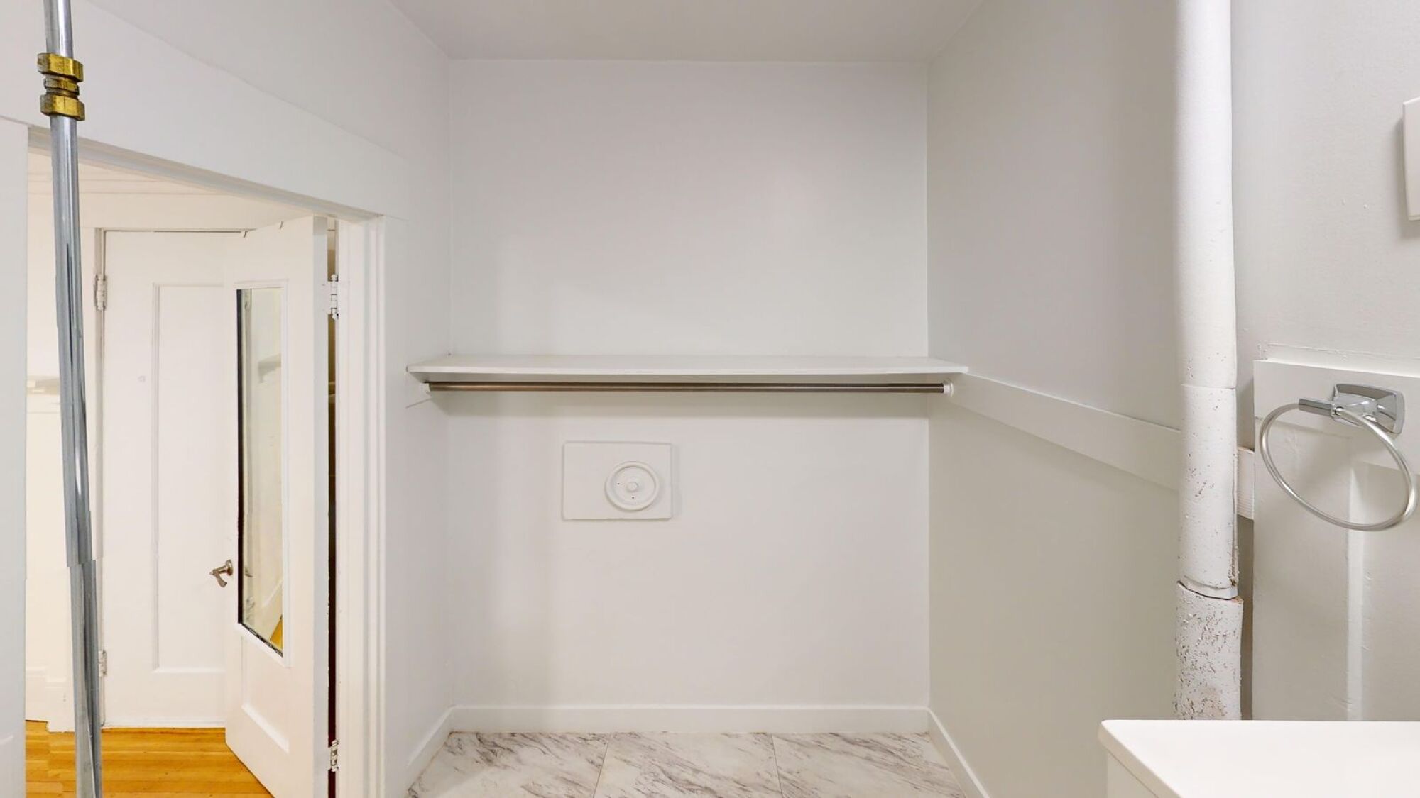 A white bathroom with a toilet and a door.
